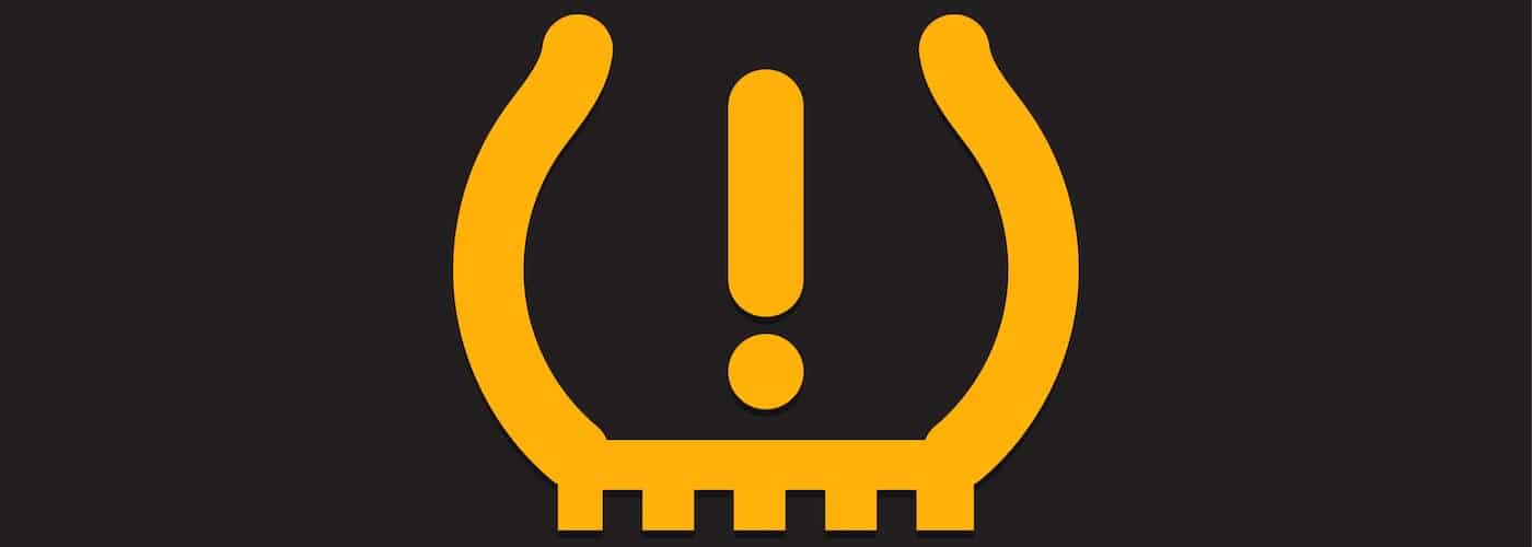 Tire pressure warning light symbol with exclamation mark on a black background.