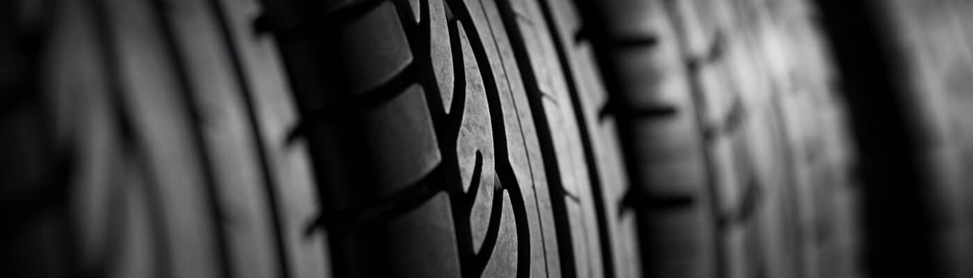 Close-up of tire treads in black and white, showing intricate patterns and texture.