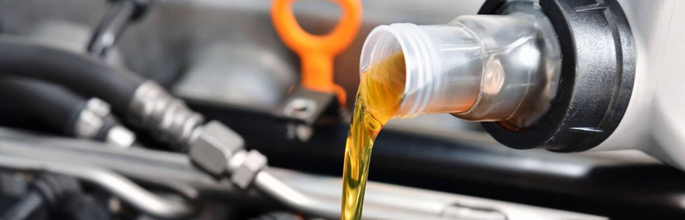 Engine oil being poured during a car maintenance procedure, highlighting vehicle care.